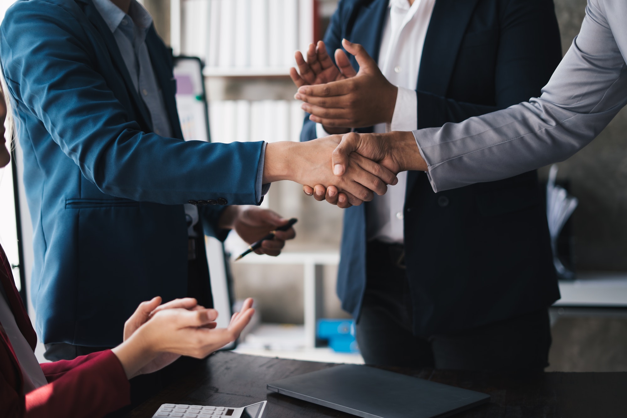 Professional businessman shaking client hand, closing successful deal.